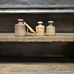 Close up of three old weights on wooden background.