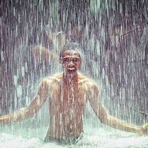 Man under a waterfall.