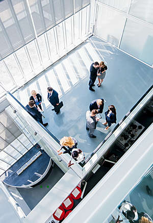 Aerial view of business coworkers standing in the lobby during break.