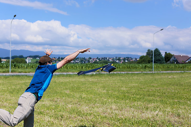 Man throwing a drone in a field